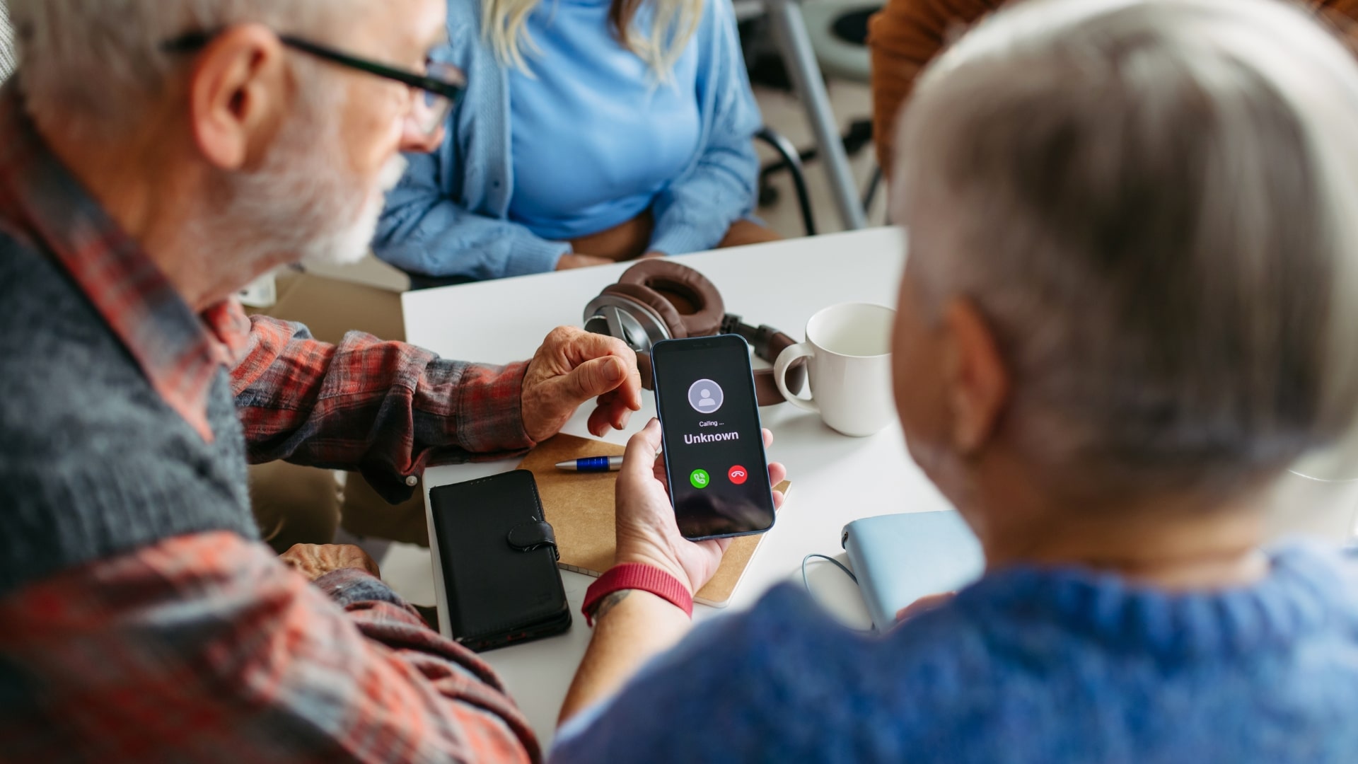 Seniors looking at cell phone with an unknown caller.